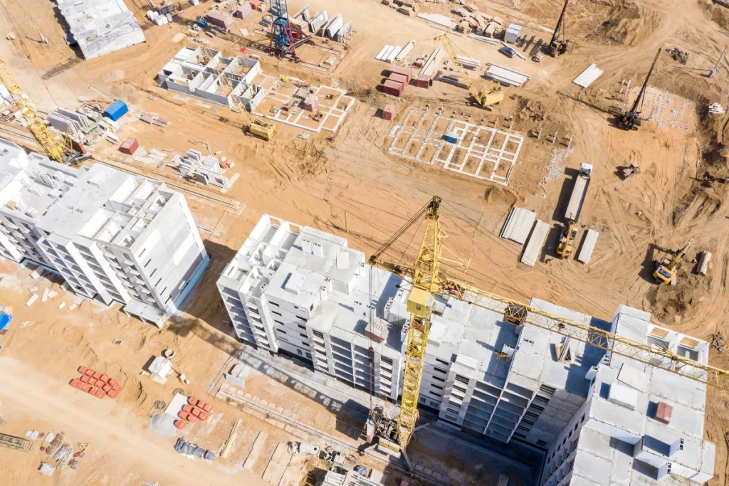 an aerial photo of a new building construction site with a tall crane and concrete building